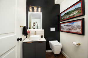 Bathroom with hardwood / wood-style floors, toilet, and vanity