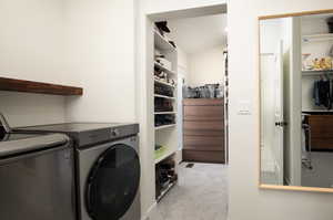 Laundry room featuring washing machine and clothes dryer and light carpet