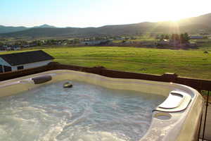 View of swimming pool with a mountain view and a hot tub