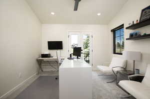 Office space featuring carpet floors, french doors, and vaulted ceiling