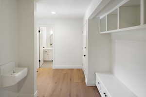 hallway with storage, drinking fountain, and powder room, with an exit near the powder room out to the hot tub.