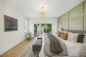 Primary bedroom with accent wall and access to the backyard patio and fireplace