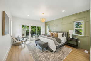 Primary bedroom with accent wall and access to the backyard patio and fireplace