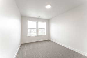Empty room with carpet and a textured ceiling
