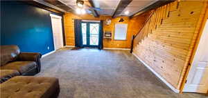 Interior space with carpet flooring, wooden walls, and ceiling fan