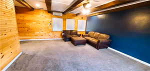 Interior space with an AC wall unit, wooden walls, ceiling fan, and carpet