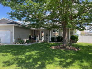 Ranch-style home featuring a garage and a front lawn