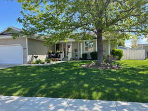 Ranch-style home featuring a garage and a front lawn