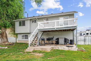 Rear view of property featuring a patio area, a wooden deck, and a yard