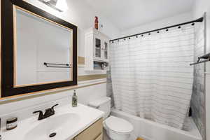 Full bathroom with vanity, toilet, and shower / tub combo with curtain