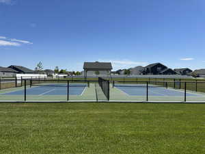 View of sport court with a yard