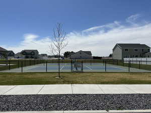 View of tennis court featuring a lawn