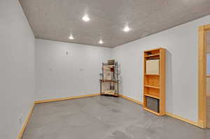 Unfurnished room featuring concrete floors and a textured ceiling