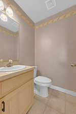 Bathroom featuring tile flooring, oversized vanity, and toilet