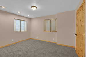 Unfurnished bedroom featuring a textured ceiling and carpet floors