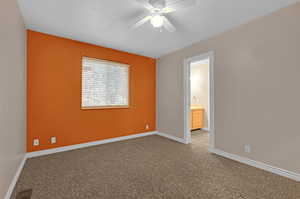 Spare room featuring a textured ceiling, carpet flooring, and ceiling fan