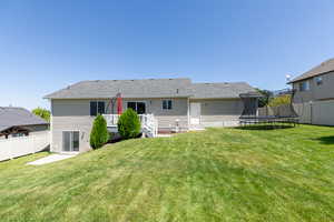 Back of property with a yard and a trampoline