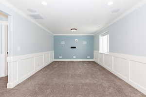 Unfurnished room featuring crown molding and carpet floors