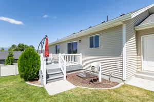 Rear view of property featuring a wooden deck and a yard