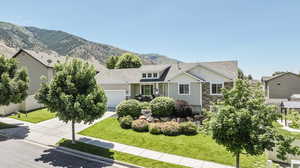 View of front of home featuring a front yard, a garage, and a mountain view