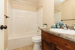 Full bathroom featuring tile flooring, bathing tub / shower combination, vanity, and toilet