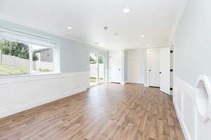 Unfurnished room with crown molding and light wood-type flooring