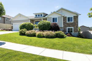 View of front facade featuring a garage and a front lawn