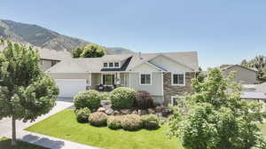 View of front facade with a garage, a mountain view, and a front lawn