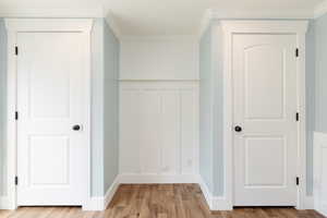 Hall with crown molding and light wood-type flooring