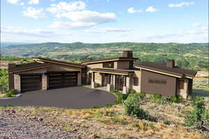 View of front of house featuring a mountain view, covered porch, and a garage