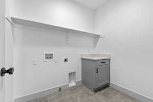 Washroom featuring gas dryer hookup, electric dryer hookup, light tile patterned floors, and hookup for a washing machine