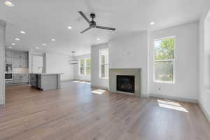 Unfurnished living room with ceiling fan and light hardwood / wood-style flooring