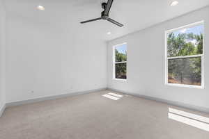 Carpeted spare room featuring ceiling fan