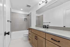 Full bathroom with tile patterned flooring, toilet, tiled shower / bath, and vanity