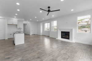 Interior space with ceiling fan, sink, and light wood-type flooring