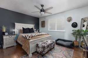 Bedroom featuring dark wood-type flooring, ceiling fan, and a textured ceiling