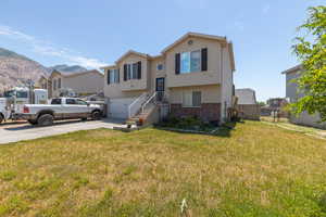 View of front of property featuring a garage and a front lawn