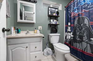 Bathroom featuring tile floors, toilet, and vanity