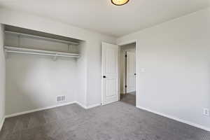 Unfurnished bedroom featuring a closet and carpet floors