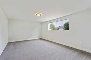 Carpeted spare room with a textured ceiling