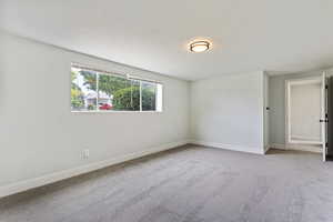 Empty room featuring carpet and a textured ceiling