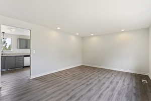 Unfurnished living room with sink and wood-type flooring