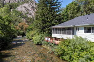 View of yard featuring a sunroom and a water view