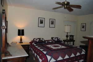 Bedroom featuring ceiling fan and a textured ceiling