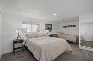 Bedroom featuring a paneled ceiling and dark colored carpet