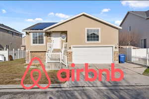 View of front of house featuring solar panels and a garage