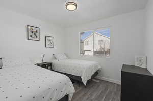 Bedroom with dark hardwood / wood-style flooring