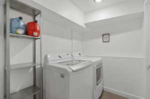 Laundry room with washer and clothes dryer and tile flooring