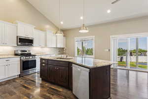 Kitchen featuring dark hardwood / wood-style floors, a kitchen island with sink, white cabinetry, appliances with stainless steel finishes, and sink