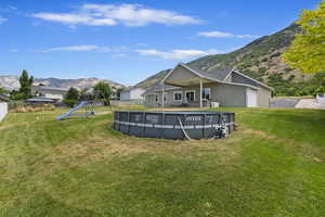 View of yard featuring a playground, a garage, and a mountain view